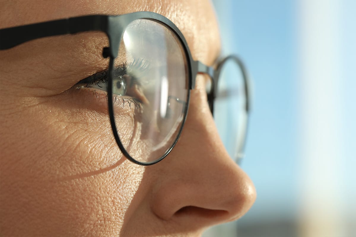 Primer plano del perfil de una persona con anteojos, enfocando el ojo y el armazón.