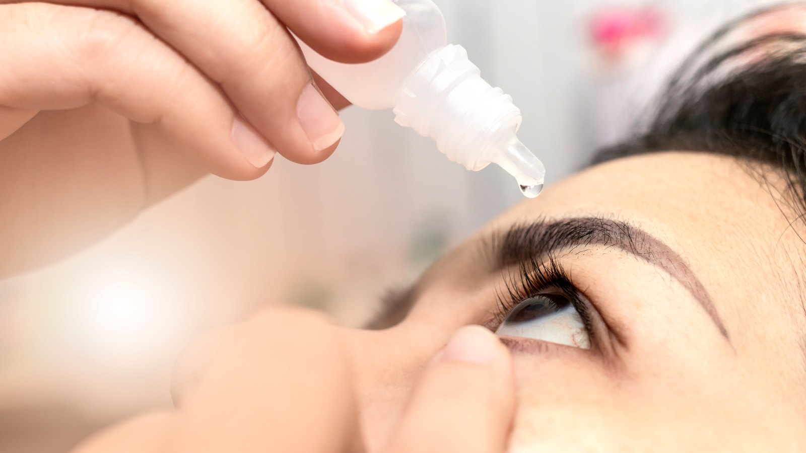 Primer plano de una gota lubricante cayendo en el ojo